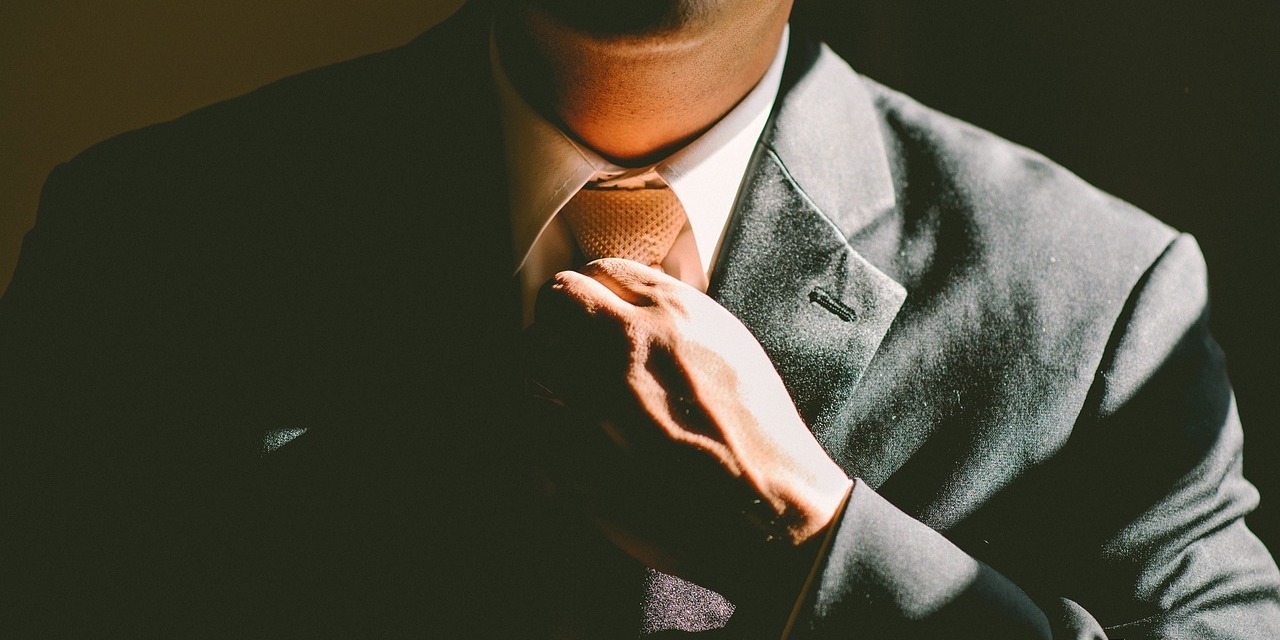 man-adjusting-tie-before-court