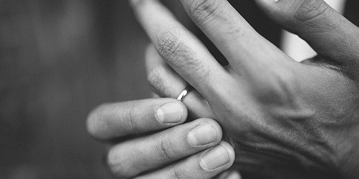 mans-hands-twisting-wedding-ring-black-and-white